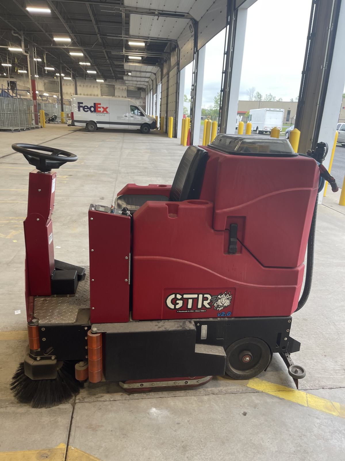 Ride-on scrubber cleaning a large facility floor